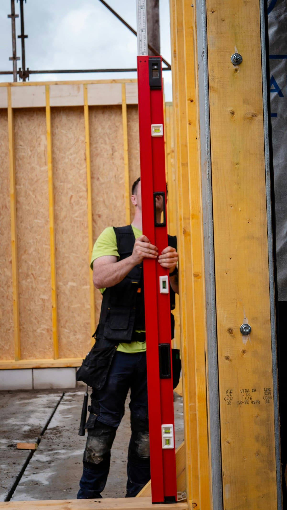 Carpenter checking a wall frame with a level
